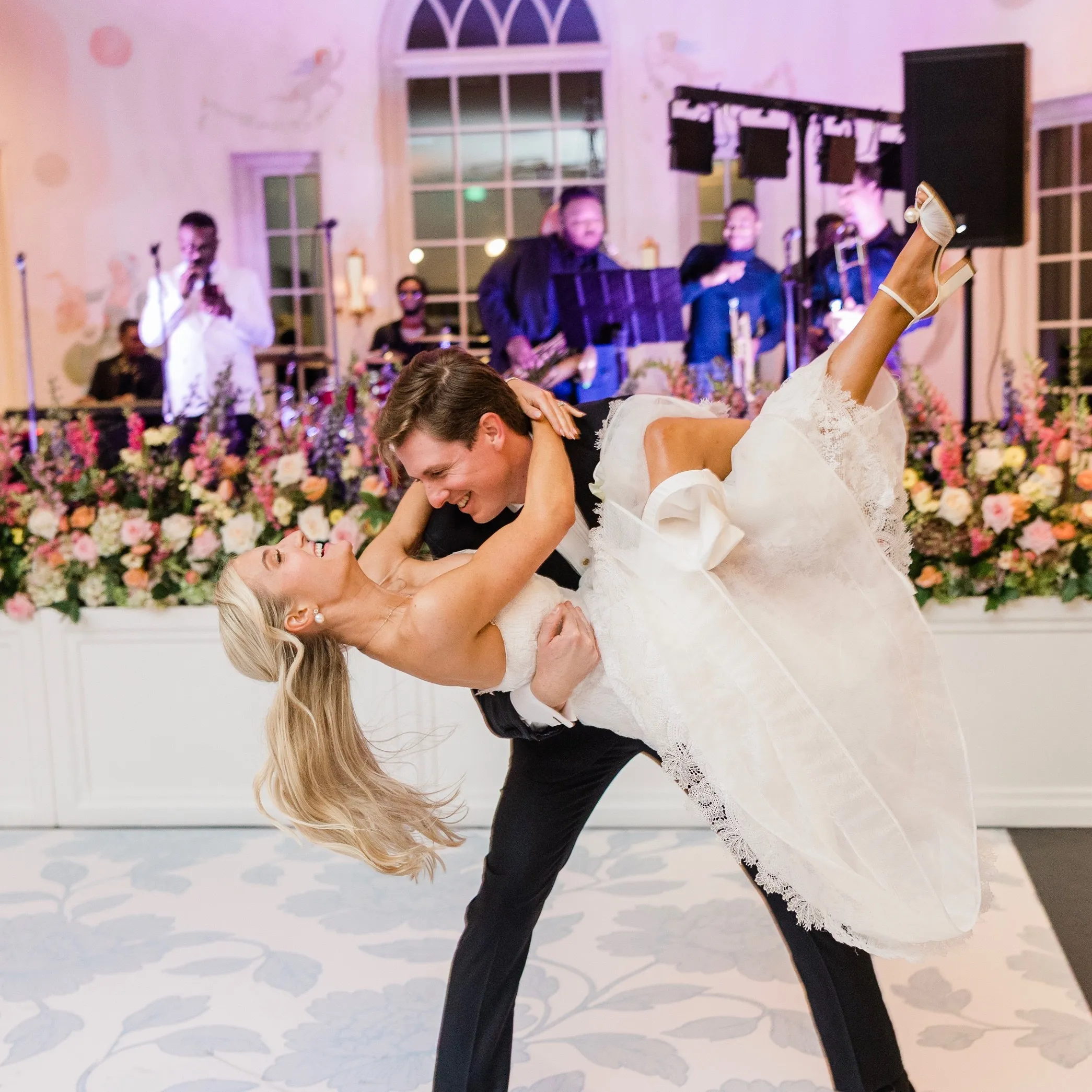 A groom dips his bride in front of a live band at a Nashville wedding reception